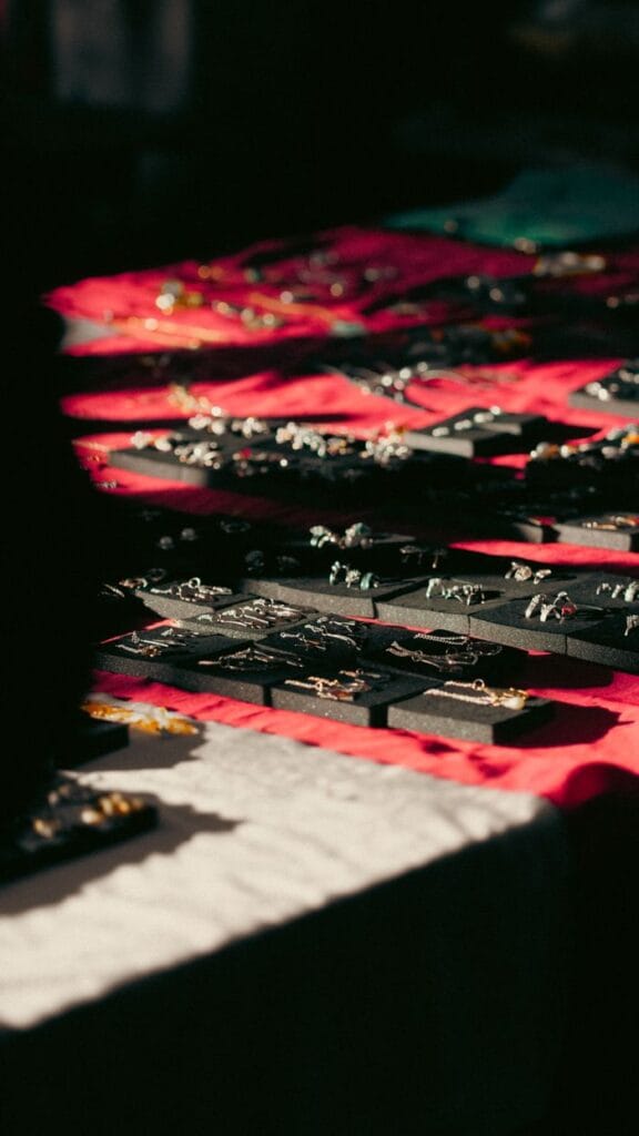 Close-up of assorted jewelry pieces elegantly displayed under warm lighting on fabric.