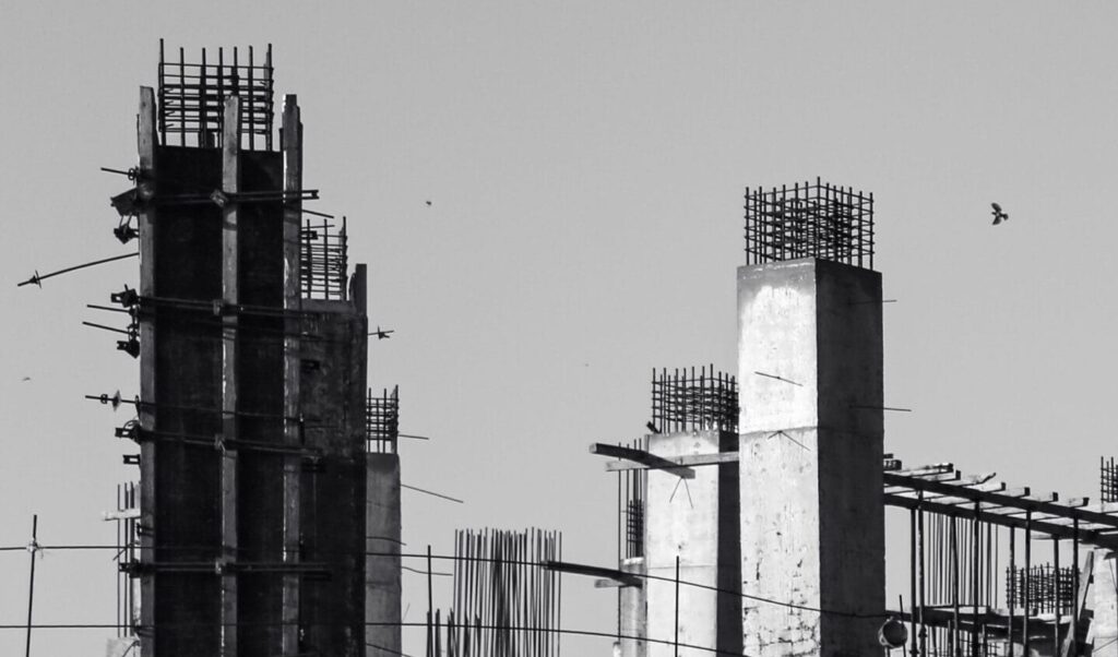 Monochrome image of a concrete construction site with vertical columns.