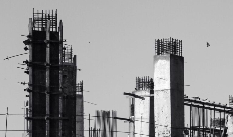 Monochrome image of a concrete construction site with vertical columns.