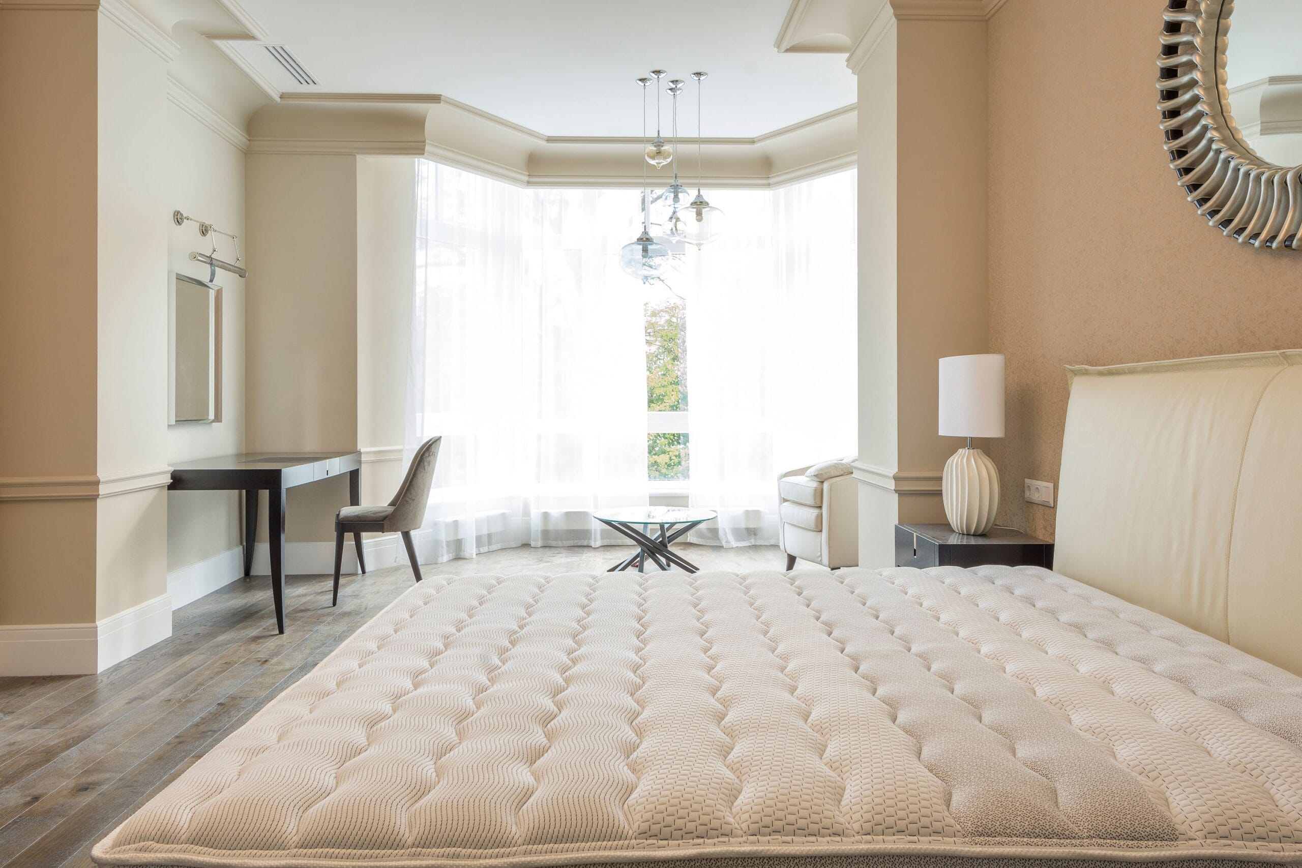 Elegant spacious bedroom with modern furniture, featuring large windows and abundant natural light.